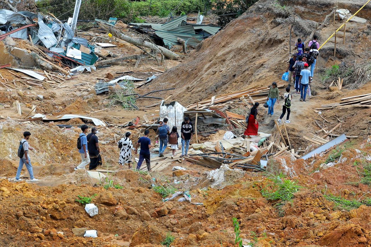 Residents walk past destroyed homes after landslides caused by Cyclone Ditwah in Ulapane village near Nawalapitiya, Kandy, Sri Lanka,  December 7, 2025. (AFP Photo)