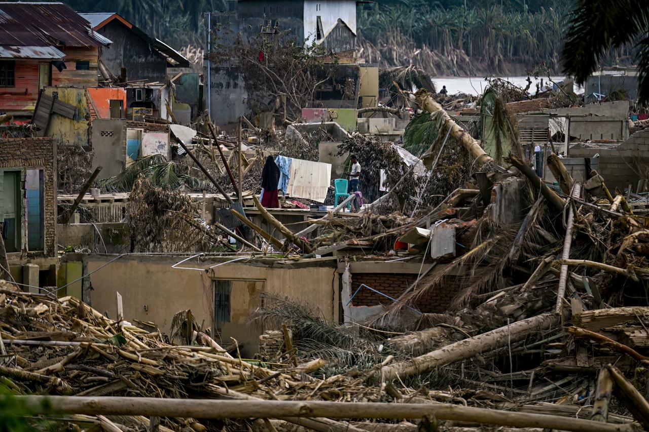 A woman hangs clothes amid the devastation caused by flash floods in Aceh Tamiang, Aceh province, December 6, 2025. (AFP Photo)
