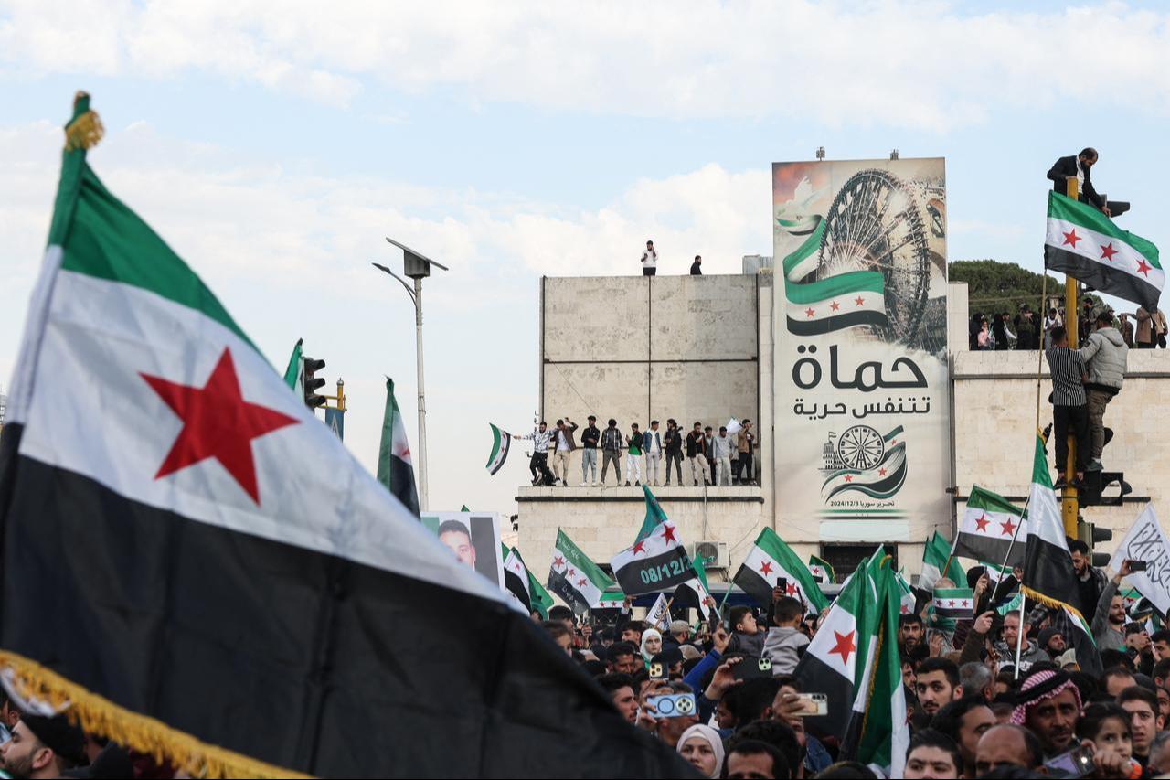 Residents gather with Syrian flags during celebrations marking one year since a lightning offensive that eventually toppled the country's longtime ruler, in central Hama on December 5, 2025. (AFP Photo)