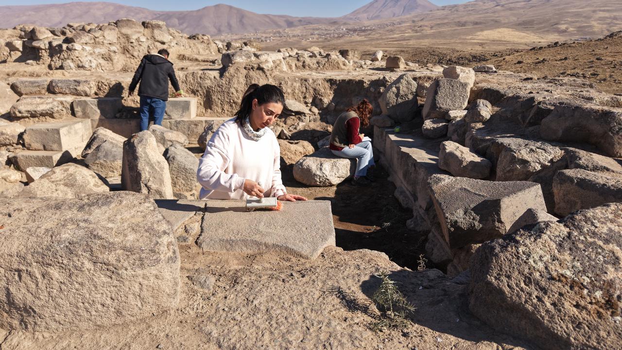 An archaeologist carefully cleans stone blocks in the temple area at Korzut Castle in the Muradiye district of Van, eastern Türkiye, Dec. 8, 2025. (AA Photo)