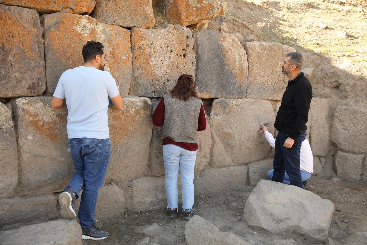 Members of the excavation team examine the massive basalt blocks of the fortification wall at Korzut Castle in the Muradiye district of Van, eastern Türkiye, Dec. 8, 2025. (AA Photo)
