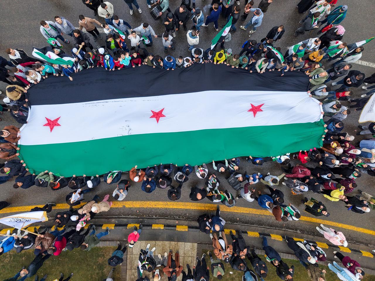 Hundreds of people gather in Umayyad Square waving Syrian flags and celebrating the first anniversary of the fall of the 61-year Baath regime in Damascus, Syria, Dec. 8, 2025. (AA Photo)