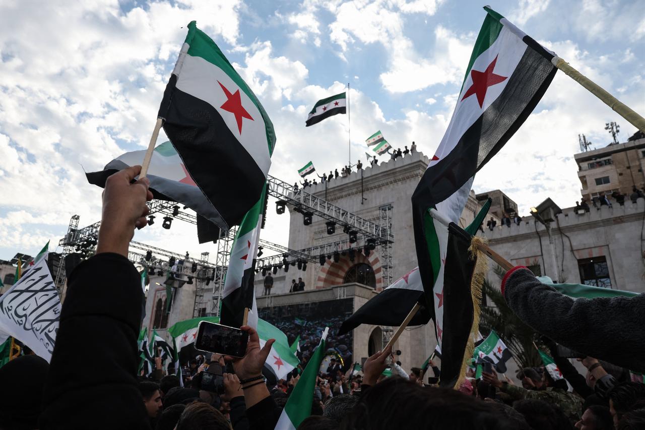 Residents gather with Syrian flags during celebrations marking one year since a lightning offensive that eventually toppled the country's longtime ruler, central Hama, Dec. 5, 2025. (AFP Photo)