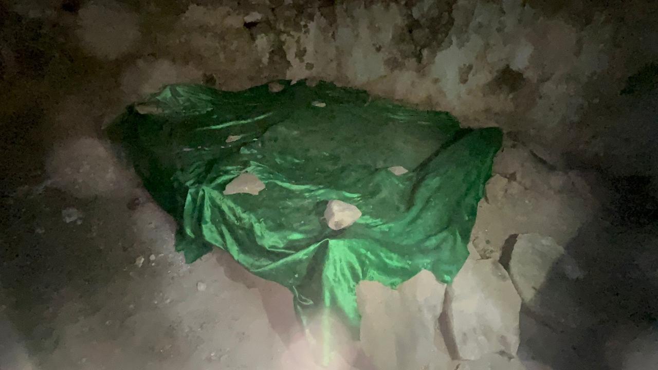 A large tomb covered with a green cloth inside the underground mosque beneath Gomek Plateau in southeastern Türkiye, Dec. 6, 2025. (IHA Photo)