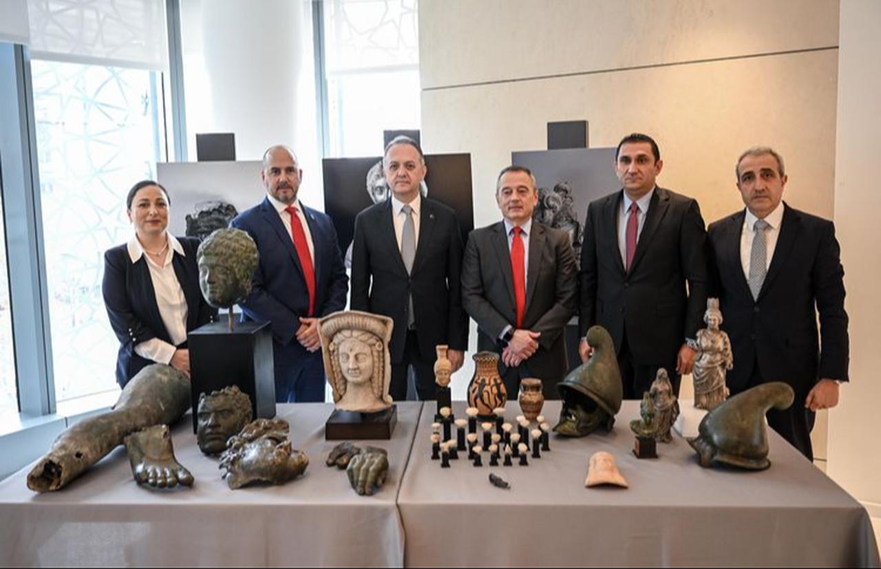 Officials from Türkiye’s Ministry of Culture and Tourism and US counterparts pose with repatriated Anatolian artifacts on display in New York, Dec. 5, 2025. (AA Photo)