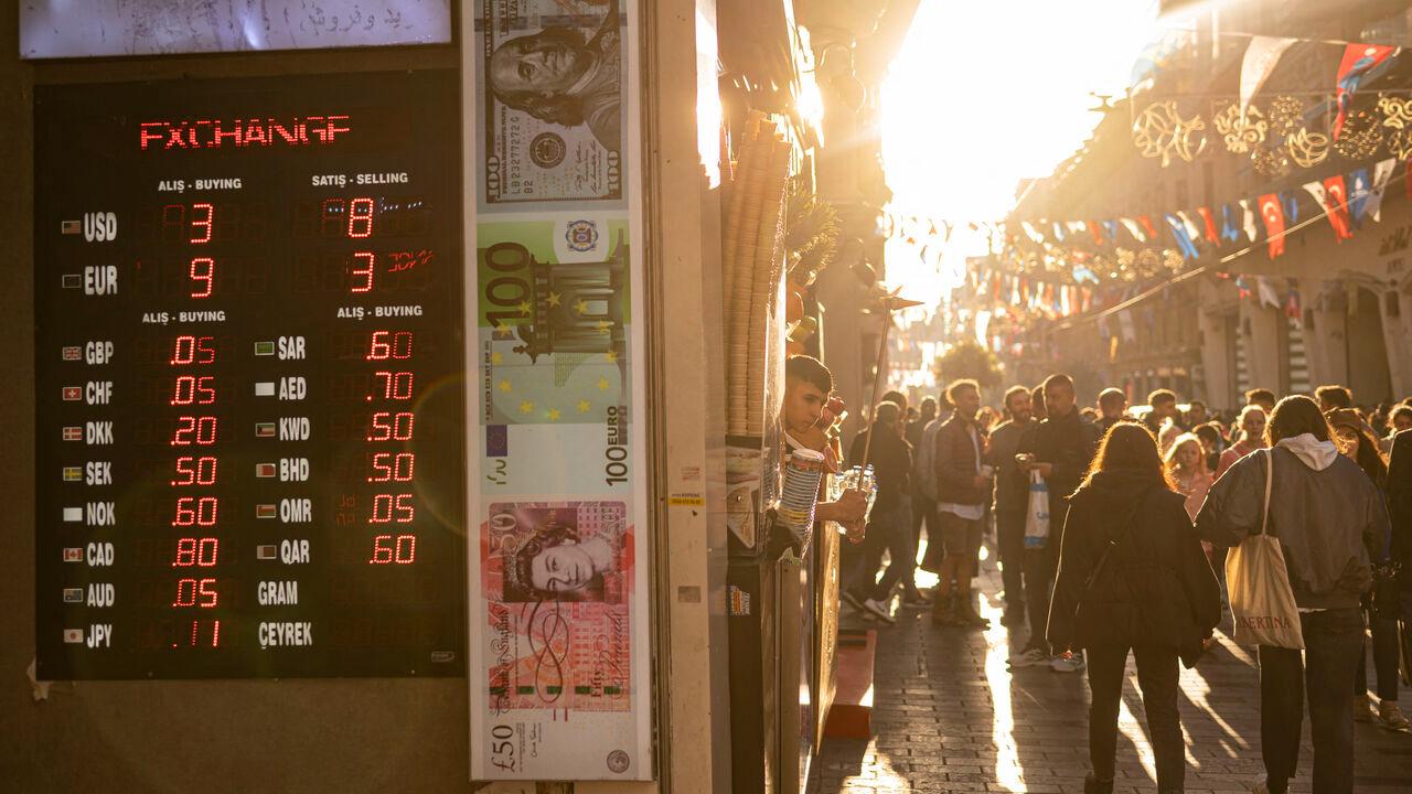 This photograph, taken on October 21, 2022, shows pedestrians walking past a currency exchange rate billboard on the crowded Istiklal Street in Istanbul. (AFP Photo)