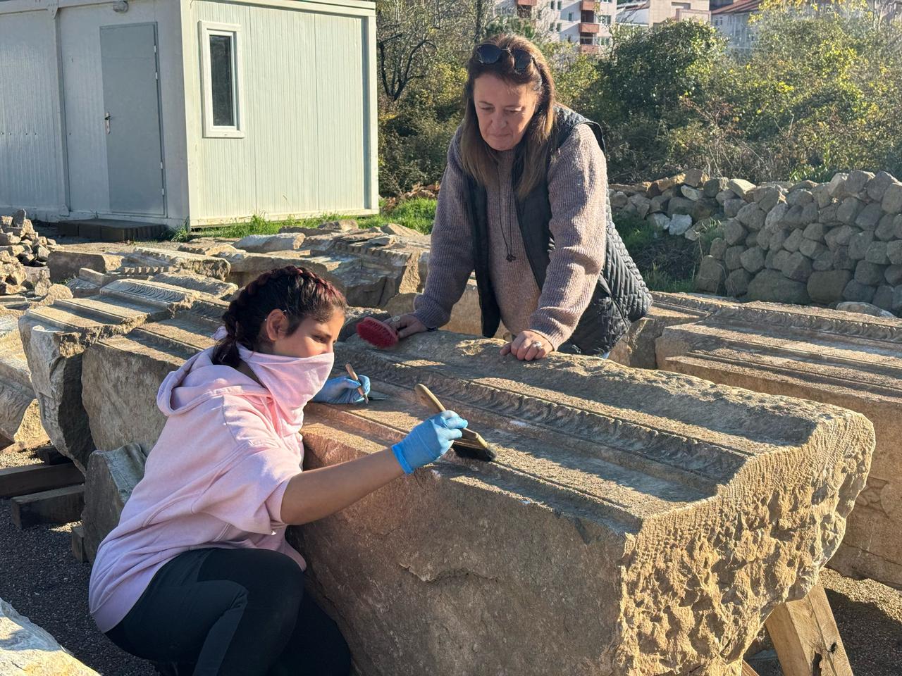 Members of the excavation team brush architectural blocks belonging to the Roman stoa at ancient city of Amastris in Amasra district of Bartin, northern Türkiye, Dec. 9, 2025. (AA Photo)