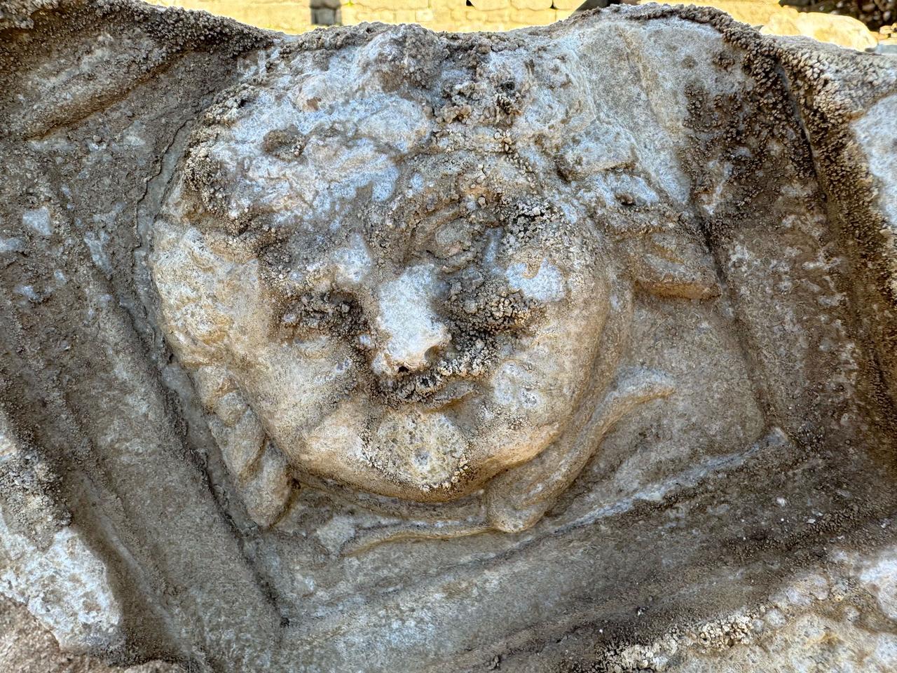 A close-up view shows the smiling Medusa relief carved into a ceiling block from the Roman stoa at ancient city of Amastris in Amasra district of Bartin, northern Türkiye, Dec. 9, 2025. (AA Photo)