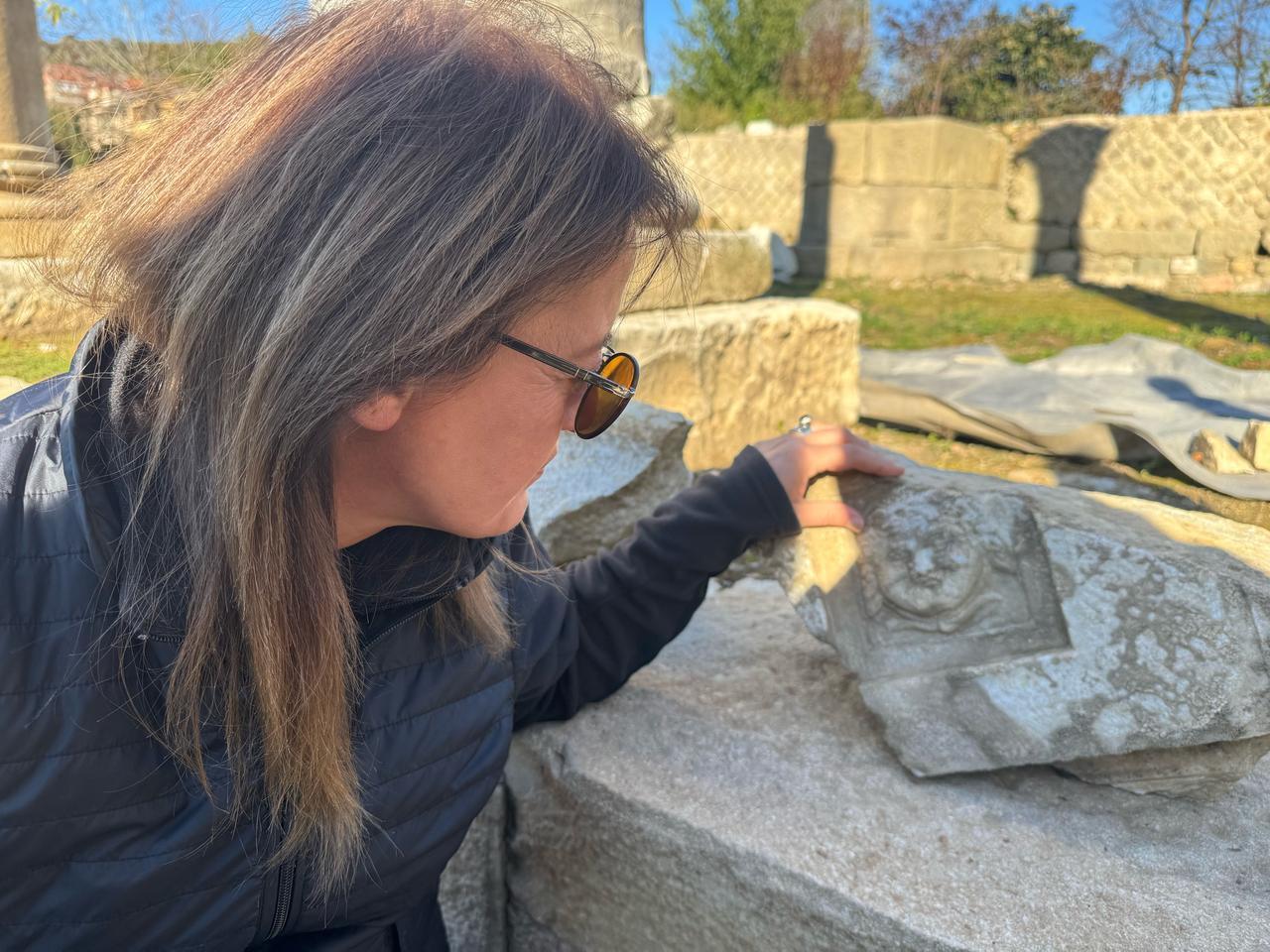 Professor Fatma Bagdatli Cam examines the smiling Medusa relief found in the Roman stoa at ancient city of Amastris in Amasra district of Bartin, northern Türkiye, Dec. 9, 2025. (AA Photo)
