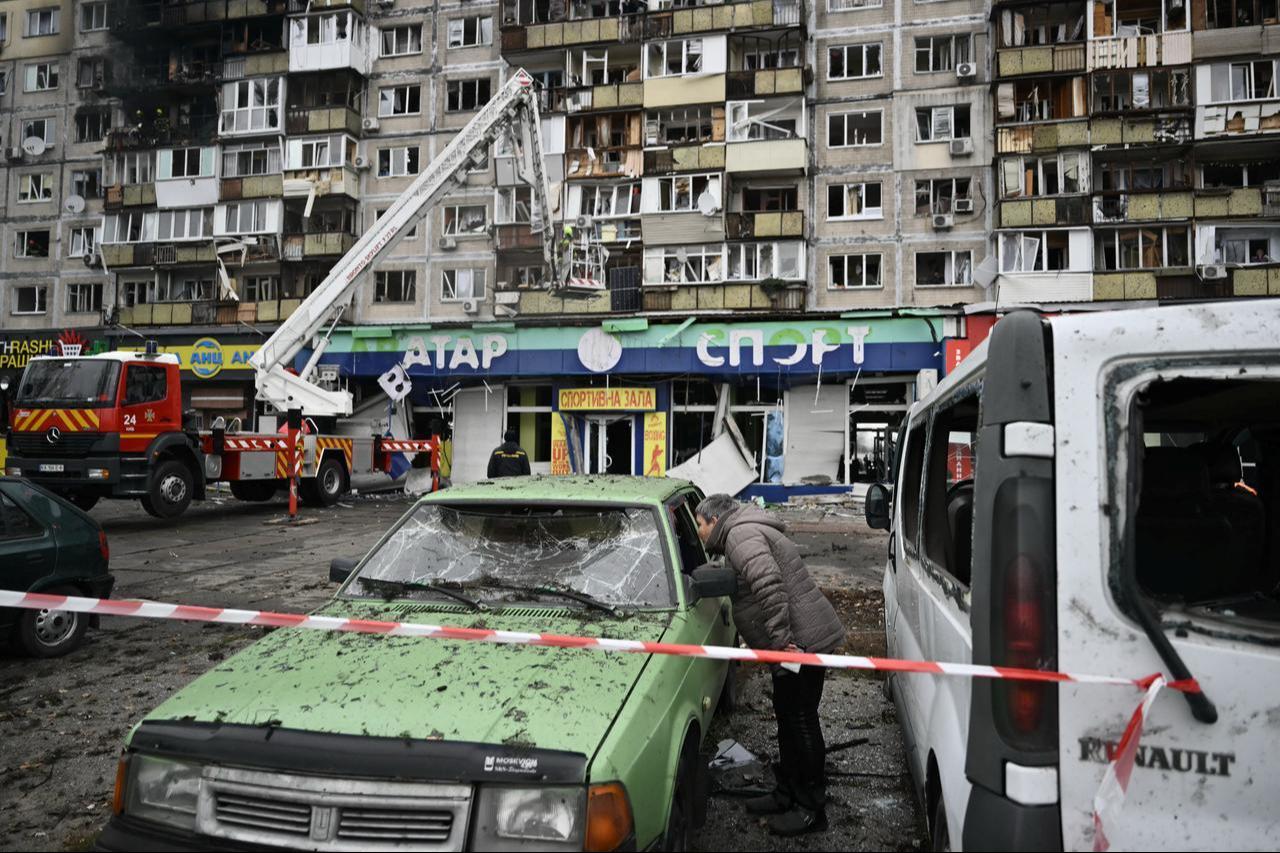 A local resident inspects a damaged car in front of a damaged residential building following an airattack in Kyiv on November 29, 2025. (AFP Photo)