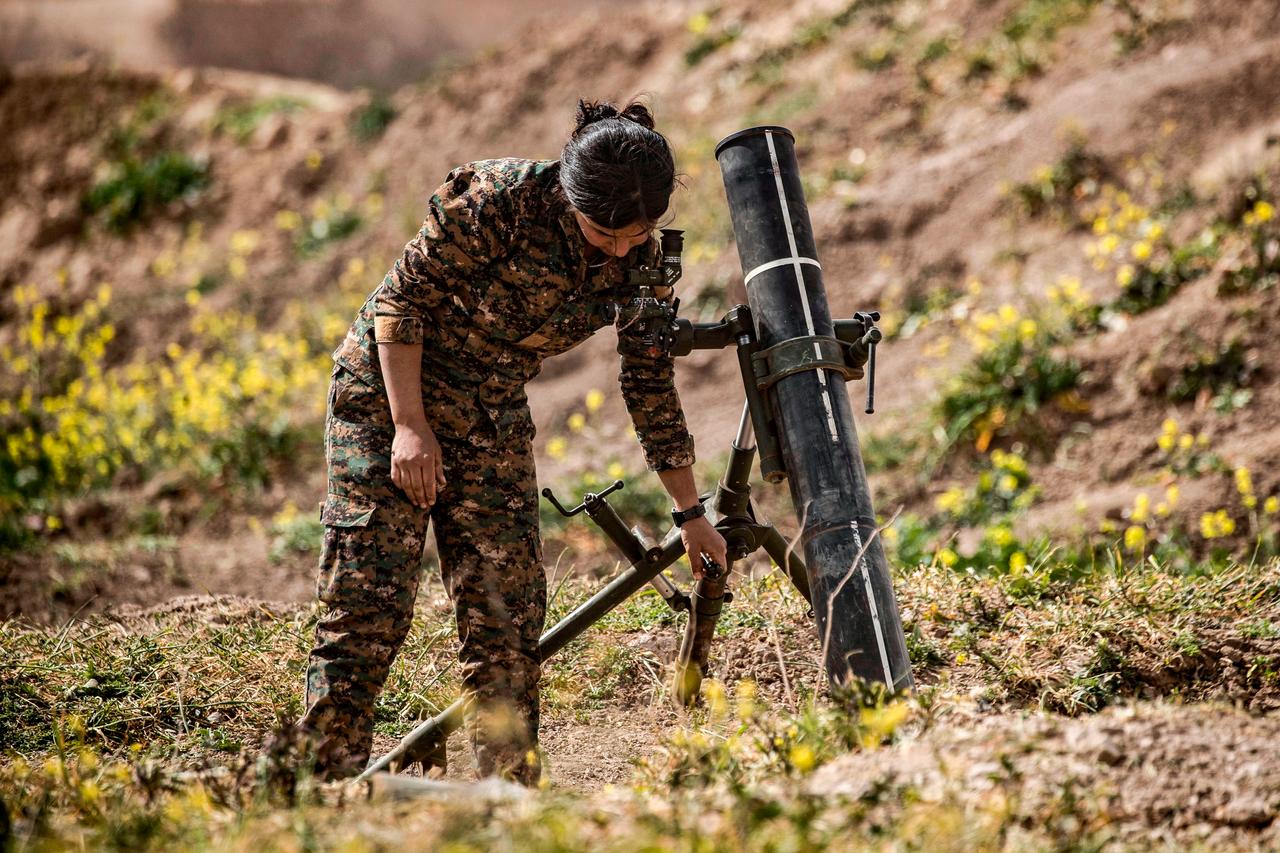 A member of the terrorist organization YPG-led SDF sets up a mortar to be fired on the frontline, in the eastern Syrian province of Deir ez-Zor on March 13, 2019. (AFP Photo)