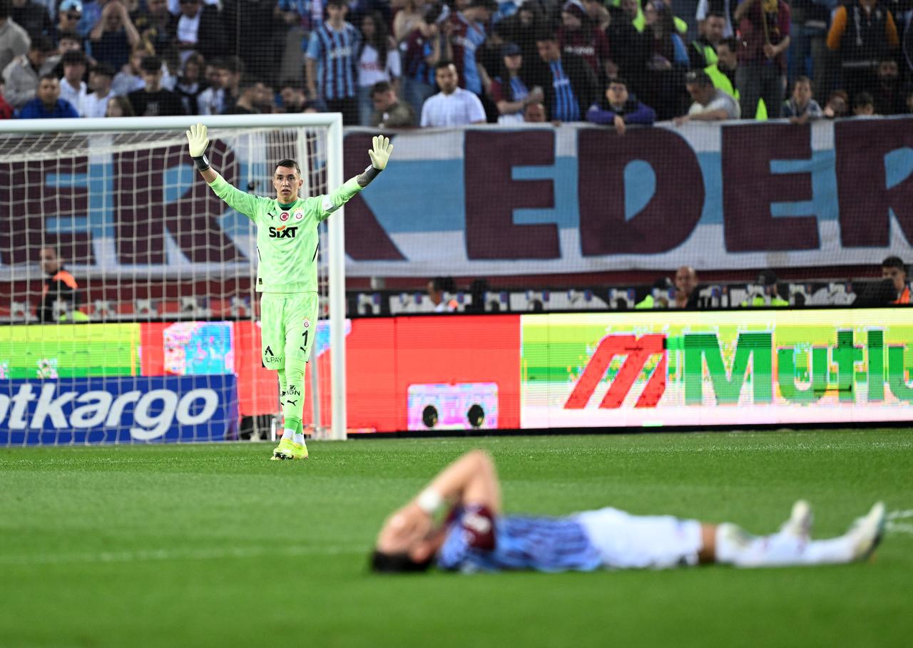 Galatasaray goalkeeper Fernando Muslera protests to the referee for Trabzonspor's Enis Destan (ground) during Turkish Super Lig week 35 football match between Trabzonspor and Galatasaray at Papara Park in Trabzon, Türkiye on May 10, 2025. (AA Photo)