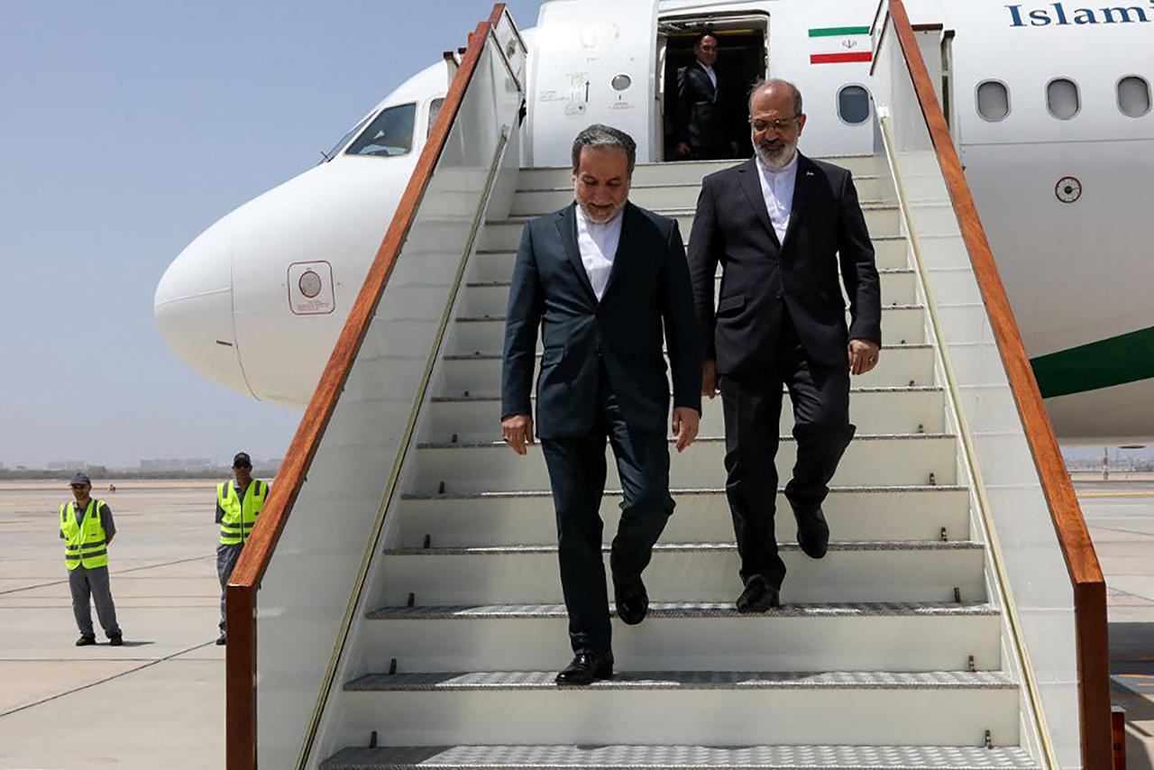 Iran's Foreign Minister Abbas Araghchi (L) descends the stairs of an aircraft upon his arrival in Muscat Iran and the United States kicked off their fourth round of nuclear talks in Muscat, Iranian media reported on May 11, 2025. (AFP Photo)