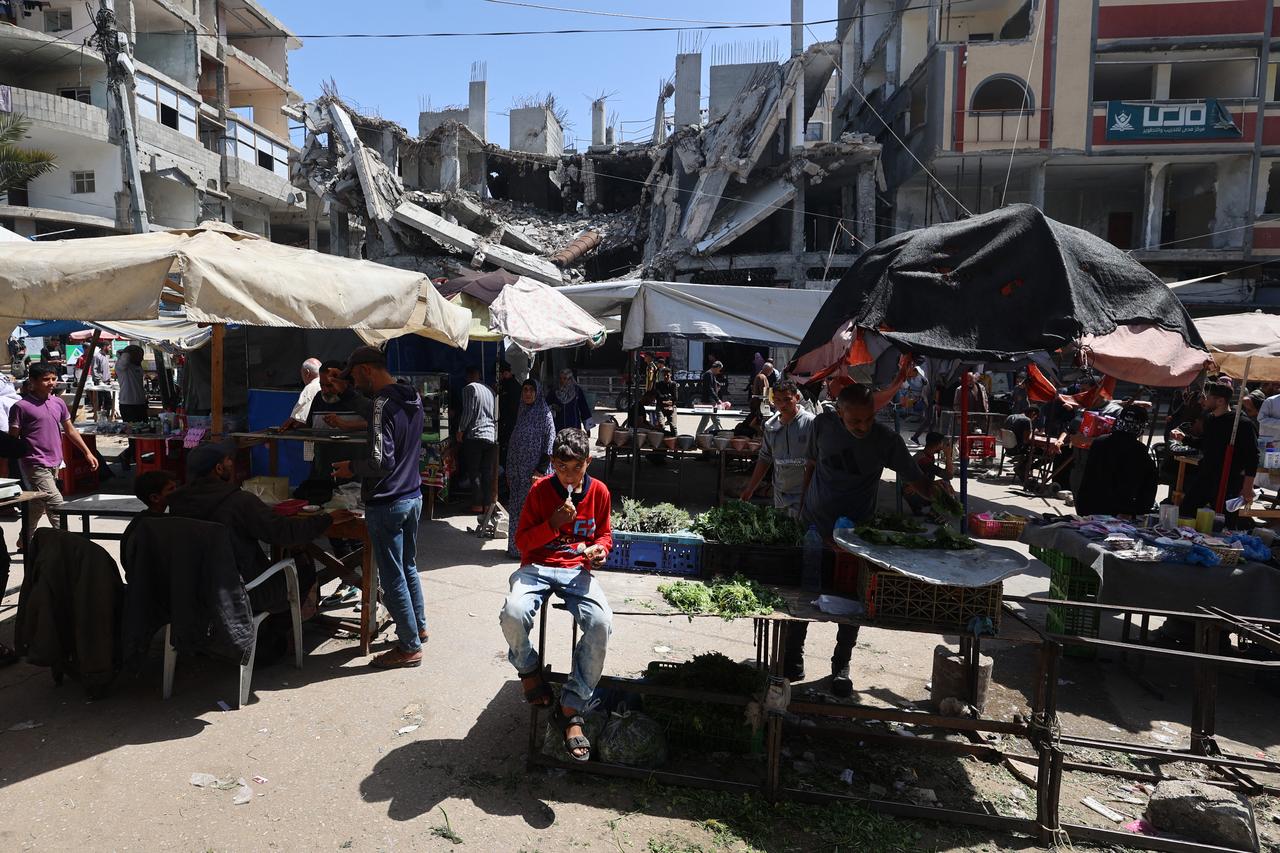 Palestinians gather at a market at the Nuseirat refugee camp in the central Gaza Strip on May 10, 2025. (Photo by Eyad BABA / AFP)