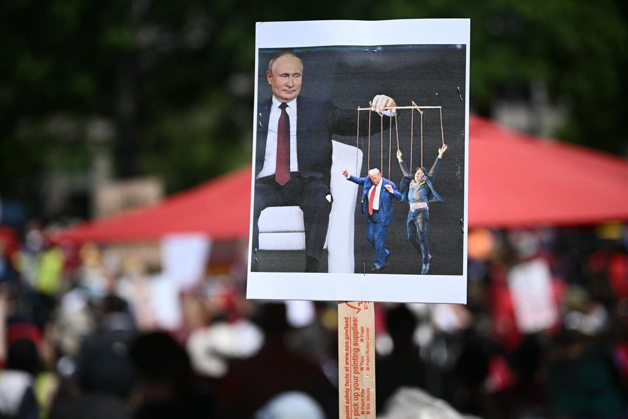 A protesters holds a signs depicting Russia's President Vladimir Putin, US President Donald Trump, and Co-leader of the Department of Government Efficiency Elon Musk at the start of the May Day Strong Coalition rally in Washington, U.S. on May 1, 2025. (AFP Photo)
