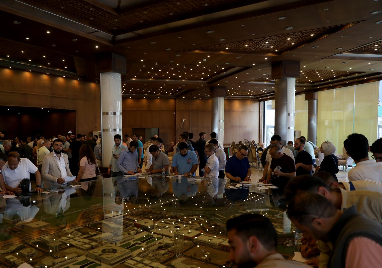 Attendees gather around a detailed architectural model on the final day of the Damascus construction and energy exhibition in Syria, on May 11, 2025. (AA Photo)