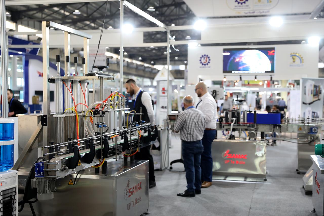 Exhibitors engage with attendees around industrial equipment at a booth during the Damascus construction and energy fair in Syria, on May 11, 2025. (AA Photo)