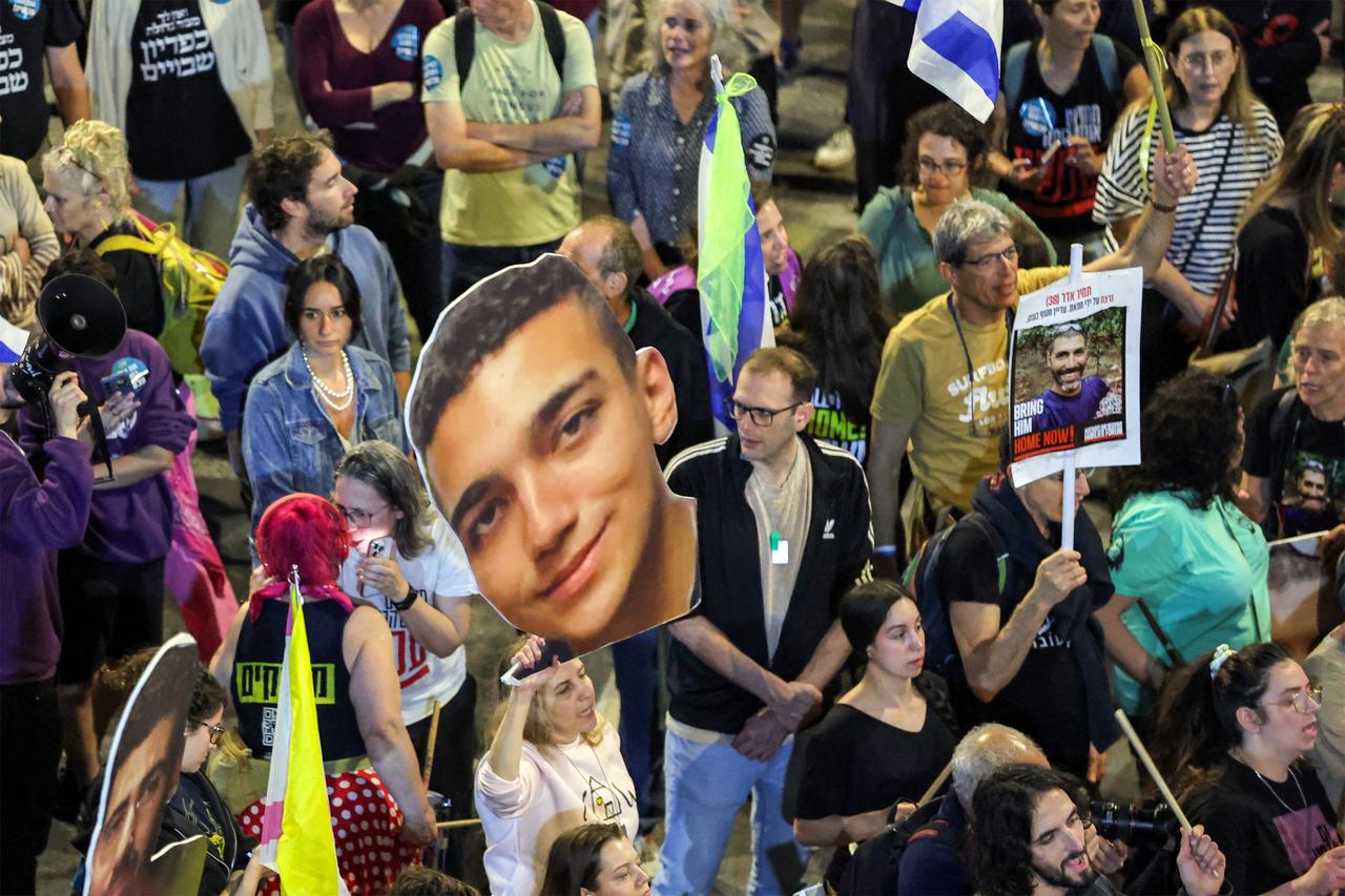  A demonstrator holds a sign showing the face of Israeli-US hostage Edan Alexander (C) during a protest calling for action to release the remaining hostages, outside the Israeli Defence Ministry headquarters in Tel Aviv on March 15, 2025. (AFP Photo)