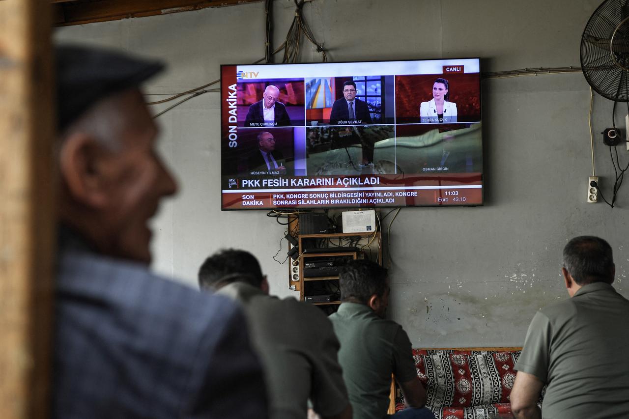 Men watch the announcement of PKK's dissolution on the News on a television screen inside a traditional Turkish tea house, in Diyarbakir, Türkiye on May 12, 2025. (AFP Photo)