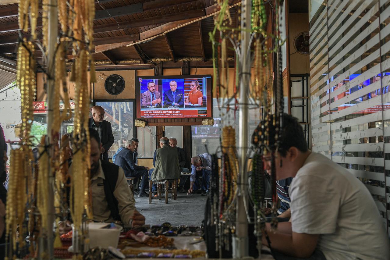 Men watch the announcement of terrorist group PKK's dissolution on the News on a television screen inside a traditional Turkish tea house, in Diyarbakir, on May 12, 2025. (AFP Photo)