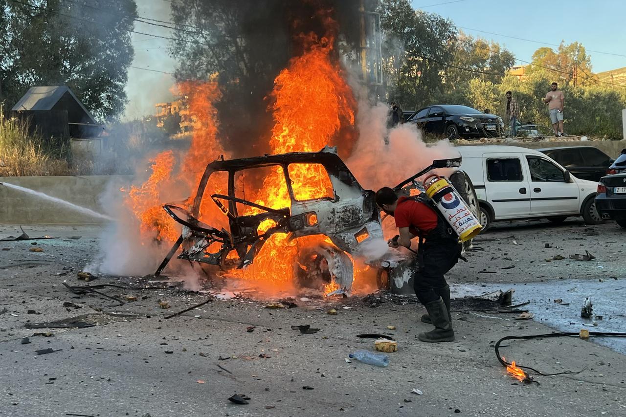 Firefighters extinguish flames from a car reportedelly targeted by an Israeli drone attack in the southern Lebanese village of Kfar Roumman on May 6, 2025. (AFP Photo)