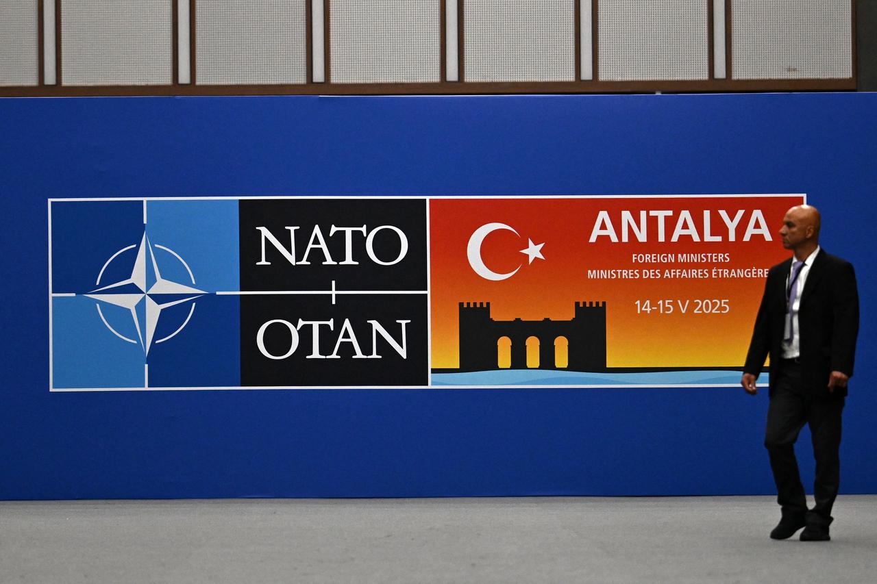 A visitor walks past a board announcing the informal meeting of NATO Ministers of Foreign Affairs, at the NEST Convention Center in Antalya on May 14, 2025. Foreign ministers from NATO countries gather in the Turkish coastal city of Antalya where they are expected to discuss ramping up defence spending, hours before the Russia-Ukraine talks are supposed to get underway. (AFP Photo)