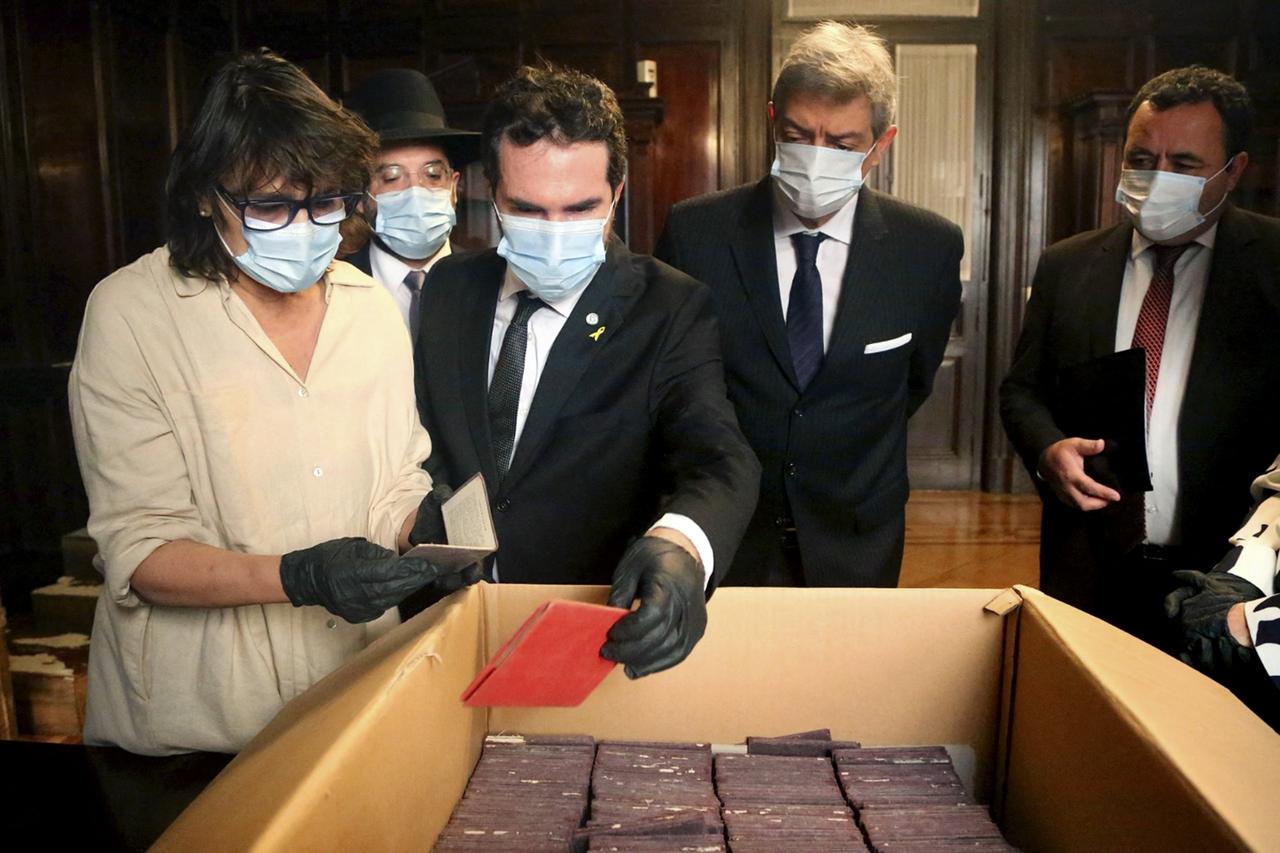 Officials observe the official unveiling of Nazi crates, seized by Argentina during World War II and recently discovered by judicial staff in the basement of the countrys Supreme Court. (AFP Photo)