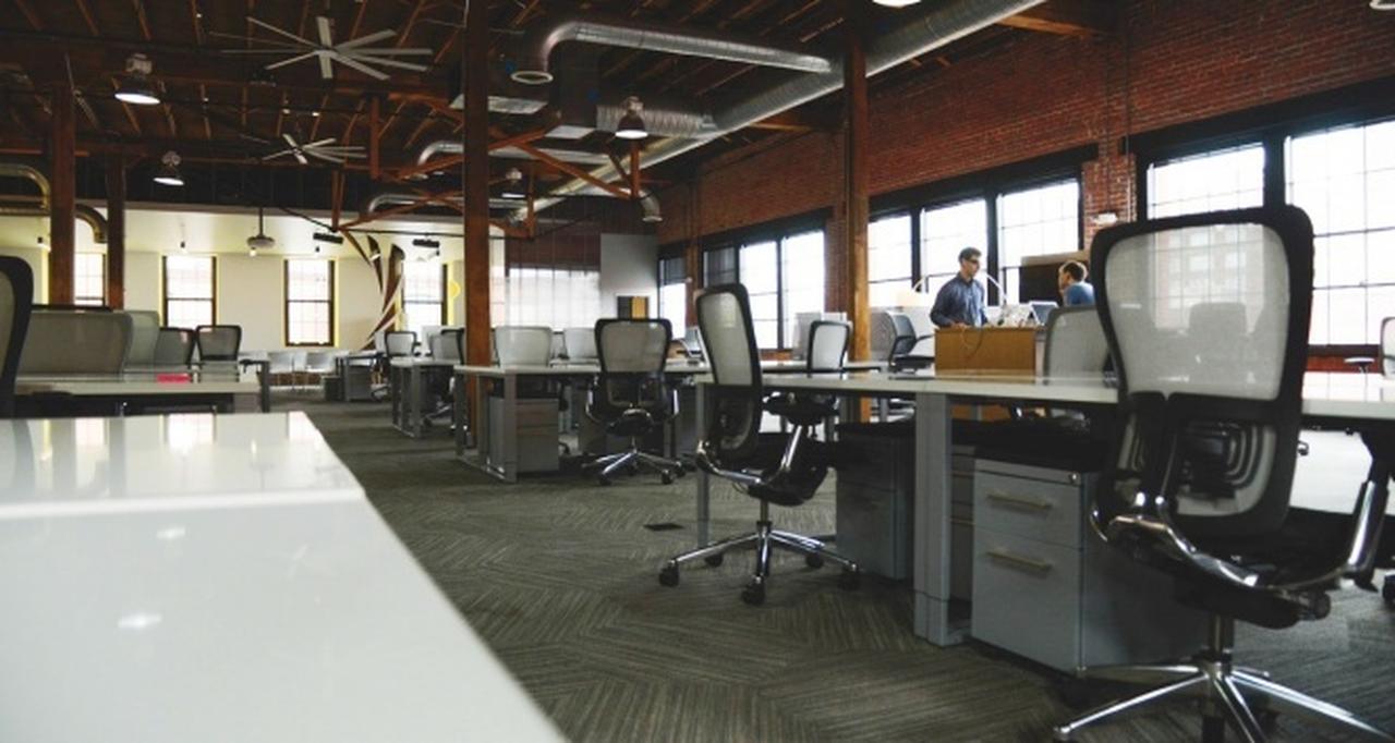 File photo shows office space with rows of empty desks and two people standing by the window in discussion, accessed on May 16, 2025. (AA Photo)
