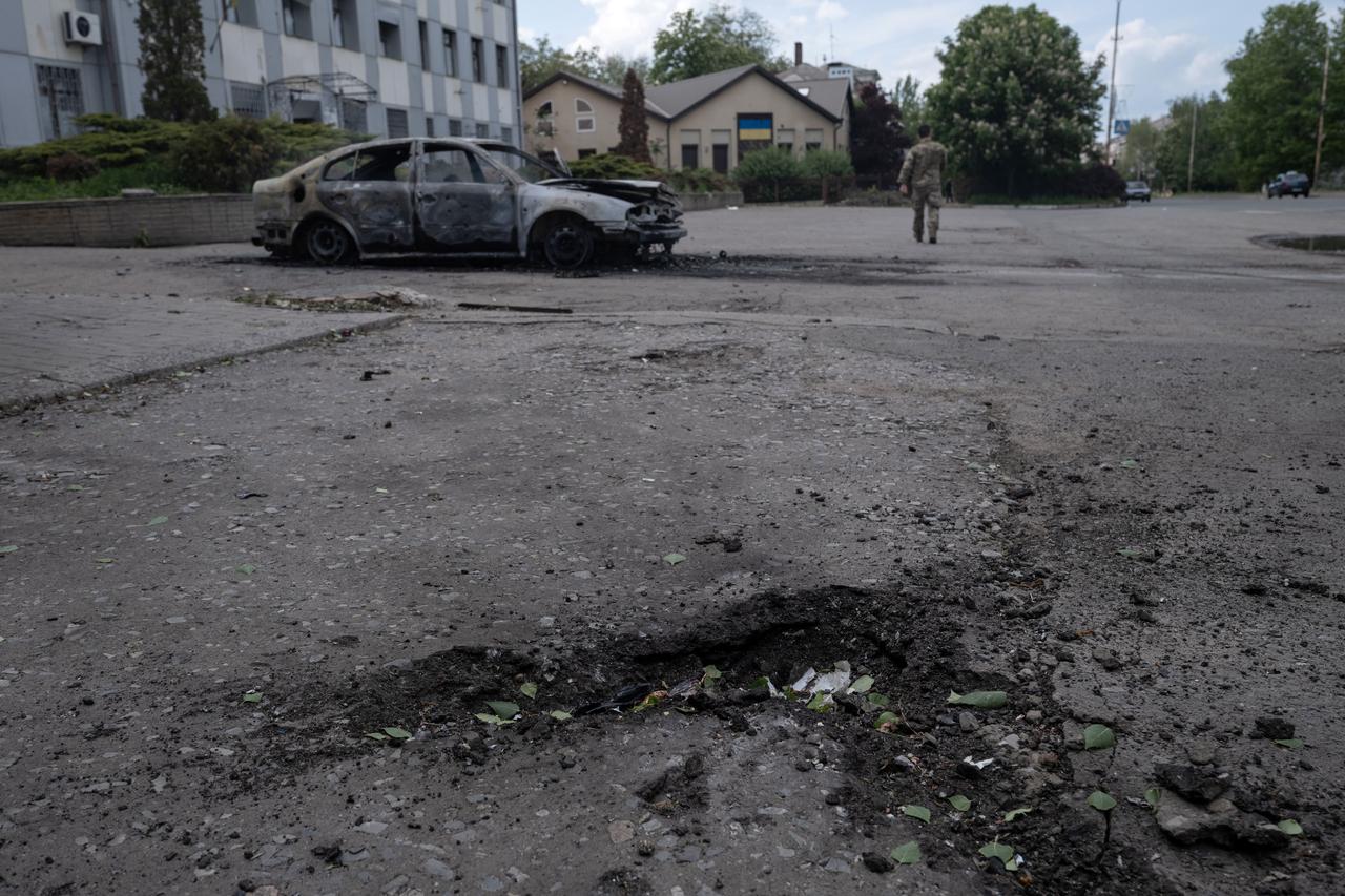 This handout photograph taken on May 16, 2025 and released on May 17, 2025 by the press service of the 93rd Kholodnyi Yar Separate Mechanized Brigade of the Ukrainian Ground Forces shows a crater next to a burnt car with the body of a killed person inside following a drone attack in Kostyantynivka, Donetsk region, amid the Russian invasion of Ukraine. (Photo by Iryna Rybakova / The 93rd Kholodnyi Yar Separate Mechanized Brigade / AFP) / RESTRICTED TO EDITORIAL USE - MANDATORY CREDIT  AFP PHOTO / HANDOUT / PRESS SERVICE OF THE 93RD KHOLODNYI YAR SEPARATE MECHANIZED BRIGADE / IRYNA RYBAKOVA  - NO MARKETING NO ADVERTISING CAMPAIGNS - DISTRIBUTED AS A SERVICE TO CLIENTS