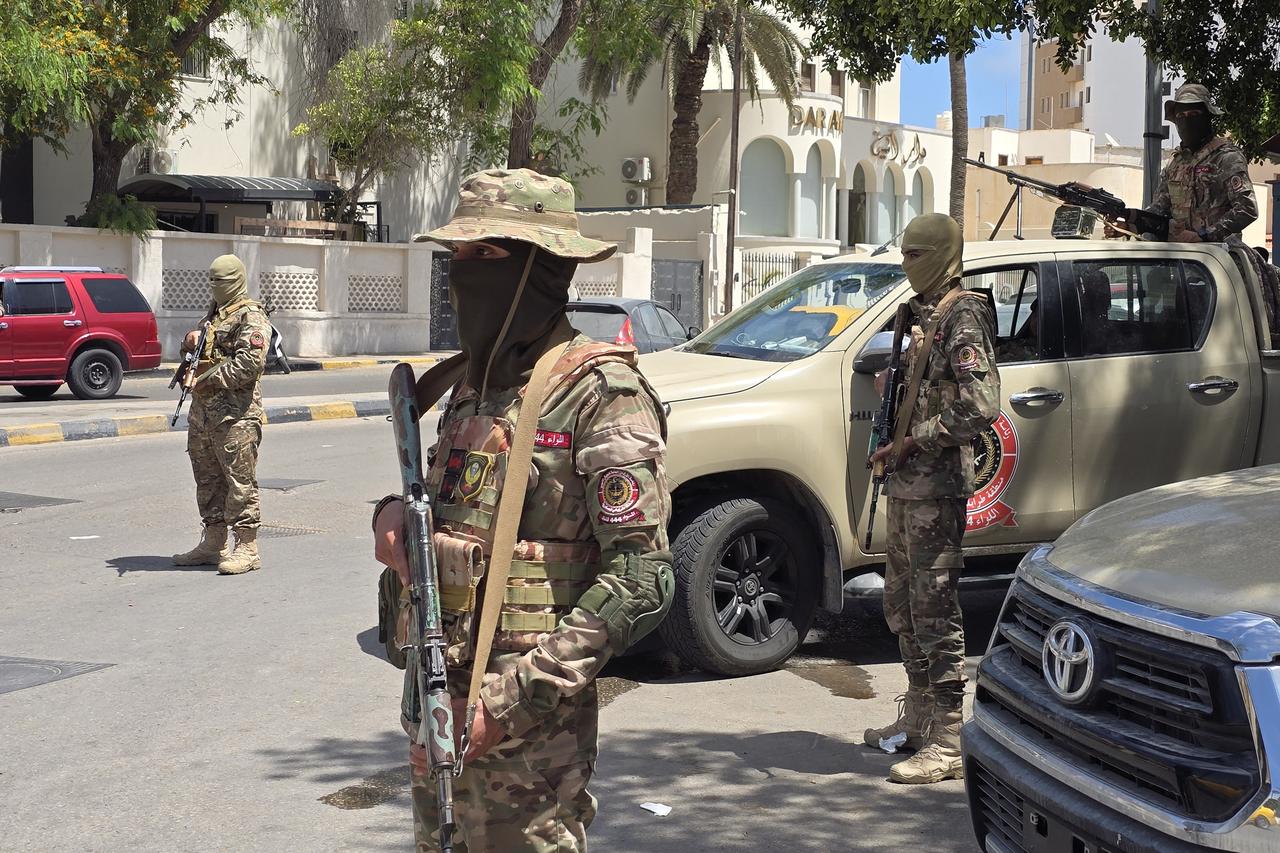 Libyan security forces man a checkpoint in Tripoli on May 13, 2025, a day after overnight clashes killed at least six people. Overnight clashes in Libyas capital killed at least six people, an emergency medical service said on May 13, with local media reporting that an armed group leader was among the dead. AFP reporters heard heavy arms fire and explosions in several areas of the capital Tripoli from 9:00 pm (1900 GMT) as violent clashes between rival armed groups rocked the city. (Photo by Mahmud Turkia / AFP)