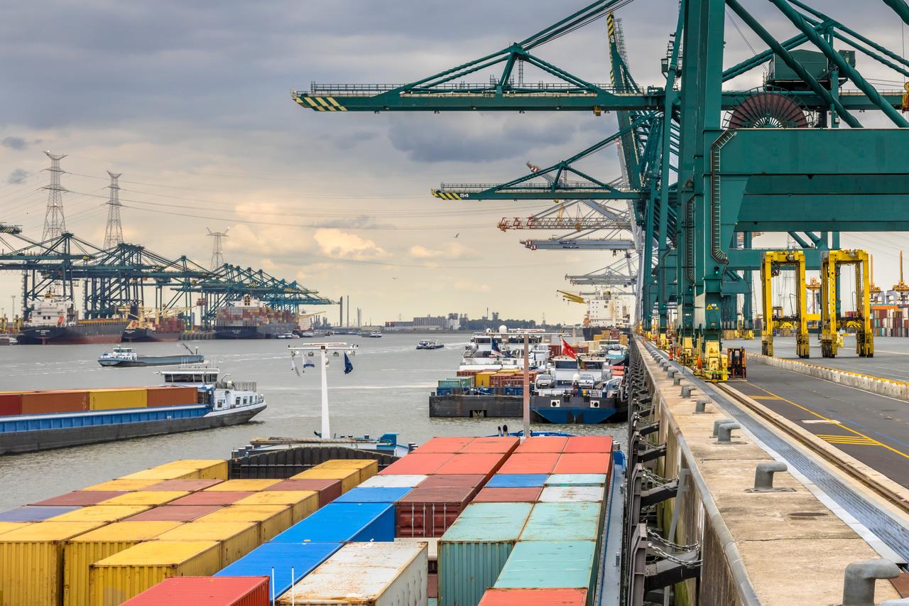 Loaded ships in busy port of Antwerp at container terminal with automated cranes and lots of vessels. Belgium