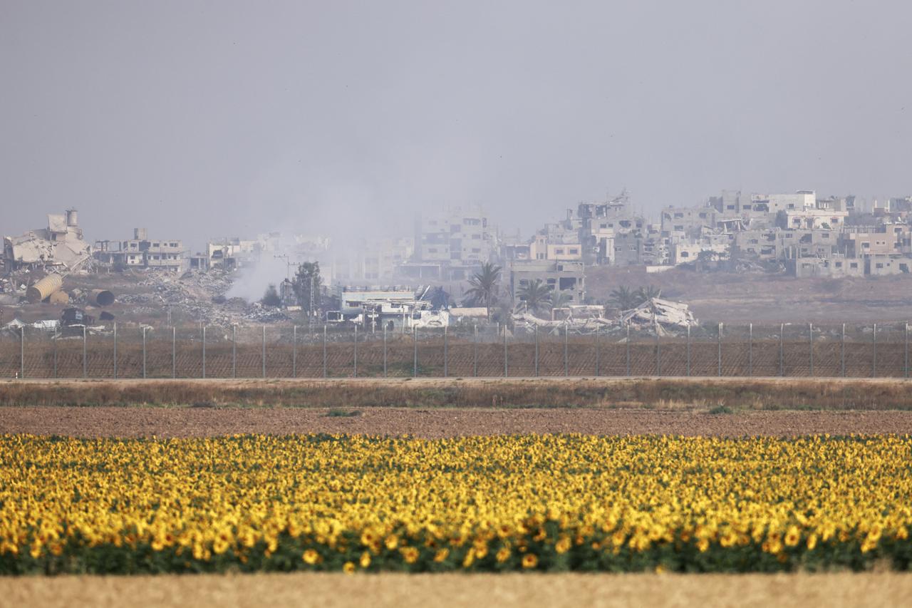 A picture taken from a sunflower field on the Israeli side of the border with the Gaza Strip shows smoke billowing due to Israeli bombardment in the besieged Palestinian territory on May 18, 2025. Gazas civil defence agency said Israeli air strikes on May 18 killed at least 33 people, more than half of them children, a day after Israel announced an expanded military campaign. (Photo by Menahem KAHANA / AFP)