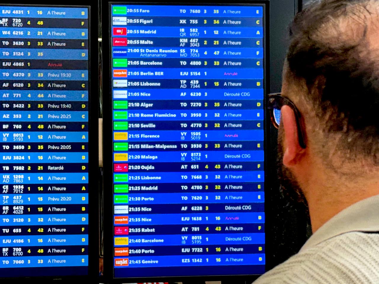 A traveller looks at a flights informations board during a breakdown in air traffic control systems at Paris-Orly airport in Orly, South of Paris, on May 18, 2025. (AFP Photo)