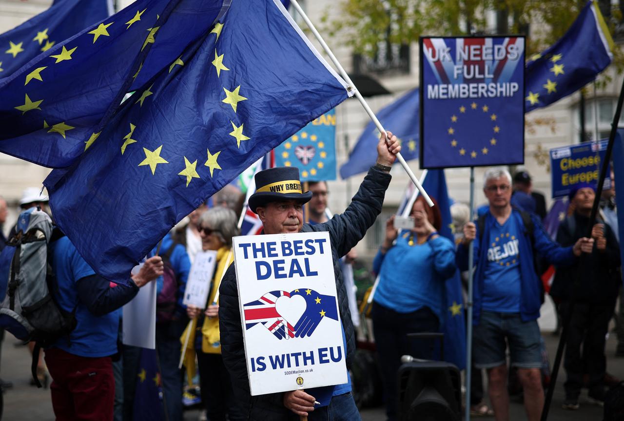 An anti-Brexit demonstrator waves flags during a protest near Lancaster House, the venue of the UK-EU Summit, in London on May 19, 2025. (AFP Photo)