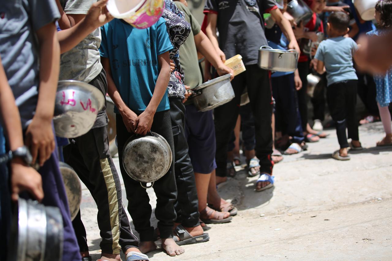 Charity organizations distribute meals to Palestinians in Al Maghazi Refugee Camp in the central Gaza Strip on May 19, 2025. (AA Photo)