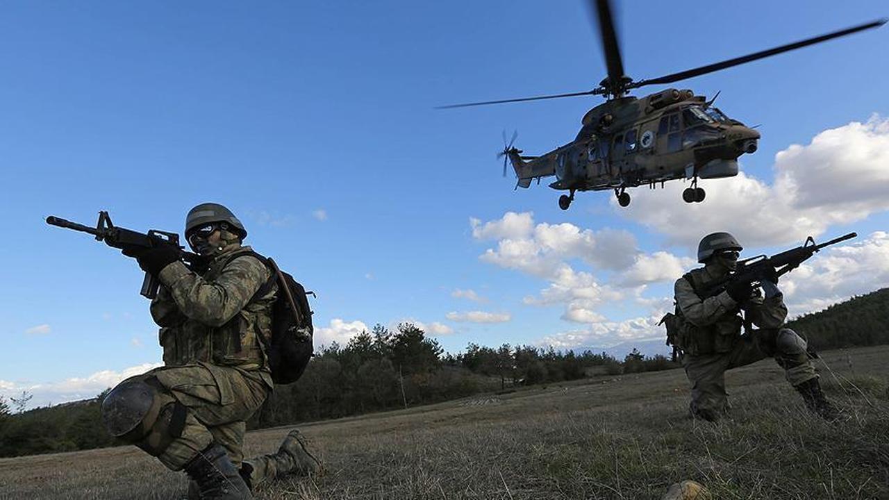 Two Turkish soldiers jump from a helicopter and quickly deploy for the operation. (AA Photo)