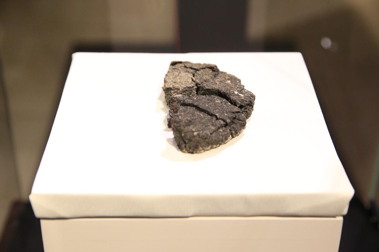 The 5,000-year-old “Kulluoba bread,” unearthed during ongoing excavations since 1996 at the Kulluoba Mound in Seyitgazi district of Eskisehir, is displayed at the ETI Archaeology Museum, Türkiye, May 21, 2025. (AA Photo)