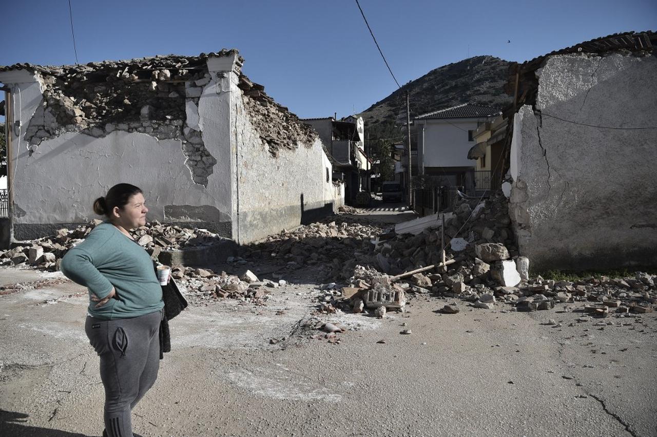 A woman stands by damaged old buildings in the village of Damasi, near the town of Tyrnavos, after a strong 6,3-magnitude earthquake hit the Greek central region of Thessaly on March 3. (AFP Photo)