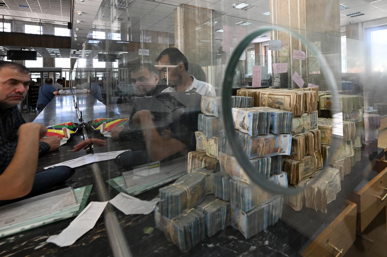 Bank notes of the local currency are piled up as people wait at the central bank in Damascus on May 21, 2025. (AFP Photo)