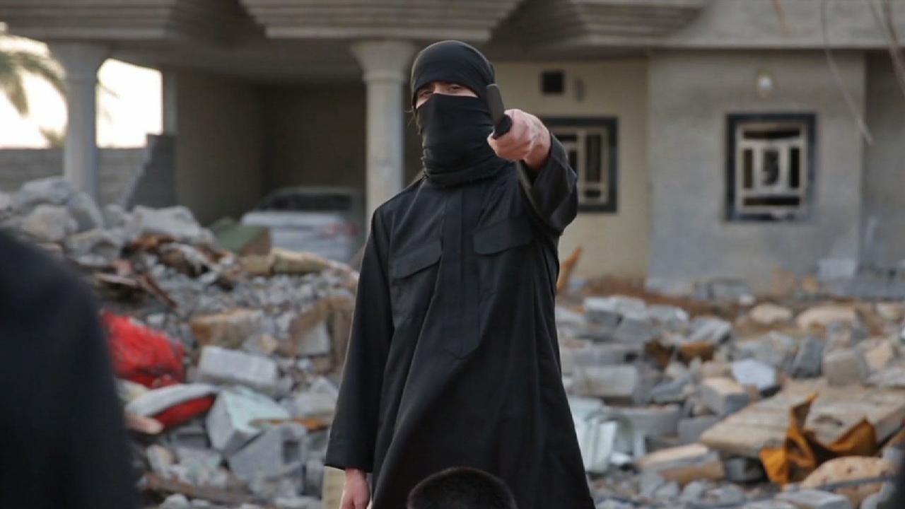 In a 2015 image surfaced online purportedly from a terrorist group, a terrorist holding a knife stands behind a prisoner, Iraq, October 31, 2015. (Photo via CNN)