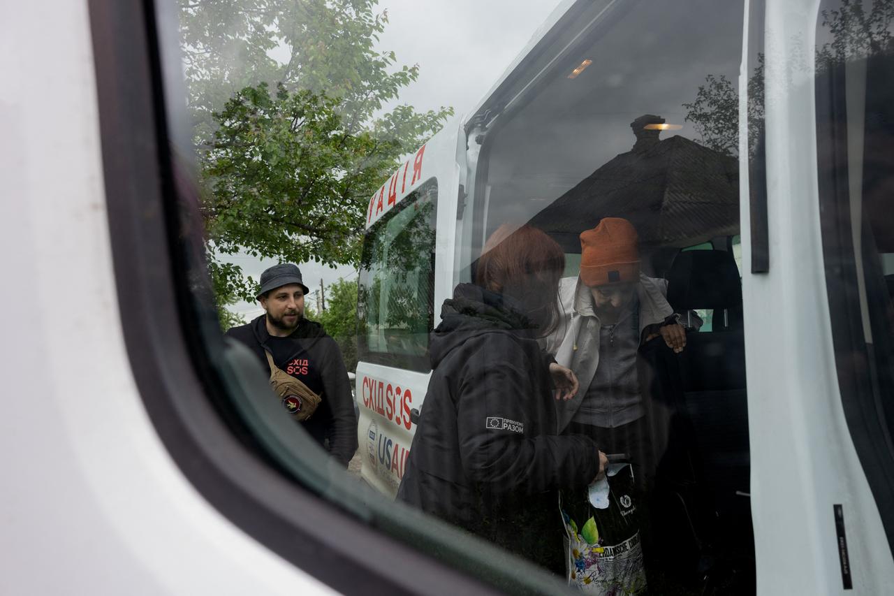A woman gets into a car during the evacuation by East SOS, which helps people evacuate from the front in Sloviansk, eastern Donetsk region on May 10, 2025. (AFP Photo)