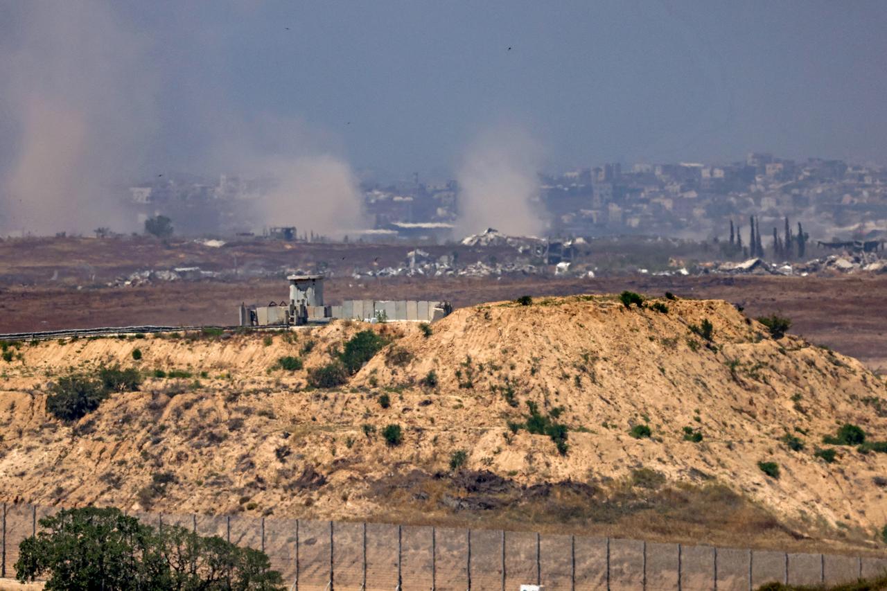 This picture taken from a position in southern Israel, on the border with the Gaza Strip, shows smoke billowing above destroyed buildings during Israeli bombardment in the besieged Palestinian territory on May 23, 2025. The Israeli army said on May 23 that over the past day, its forces had attacked  military compounds, weapons storage facilities and sniper posts  in Gaza. (Photo by AHMAD GHARABLI / AFP)