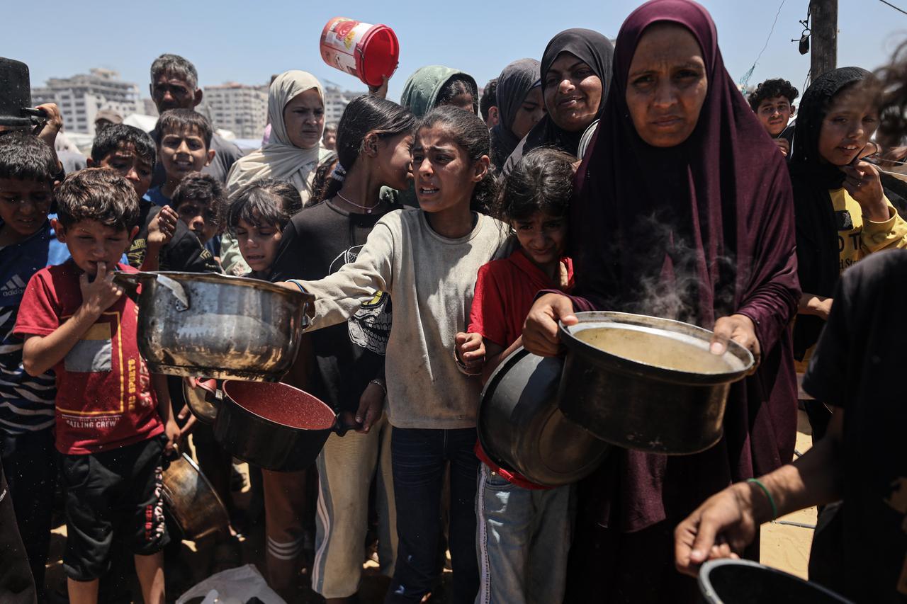 GAZA CITY, GAZA - MAY 24: Palestinians line up to receive clean drinking water and hot meal, distributed by charity organizations, as people struggle with difficult living conditions due to ongoing Israeli attacks in Gaza City, Gaza on May 24, 2025. ( Abdalhkem Abu Riash - Anadolu Agency )