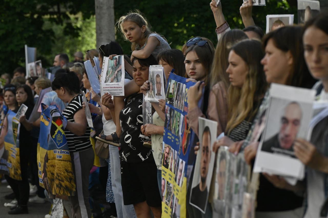 People hold portraits of their missing or captured relatives and friends as they wait for the arrival of freed Ukrainian POWs in the Chernigiv region on May 23, 2025, amid the Russian invasion of Ukraine. Ukraine and Russia began a major prisoner exchange on May 23, 2025. (AFP Photo)