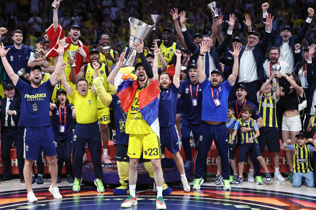 Fenerbahces Serbian forward #23 Marko Guduric lifts the championship trophy as he and his teammates celebrate during the podium ceremony after winning the Turkish Airlines Euroleague Basketball final match against AS Monaco at Etihad Arena in Abu Dhabi on May 25, 2025. (AFP Photo)