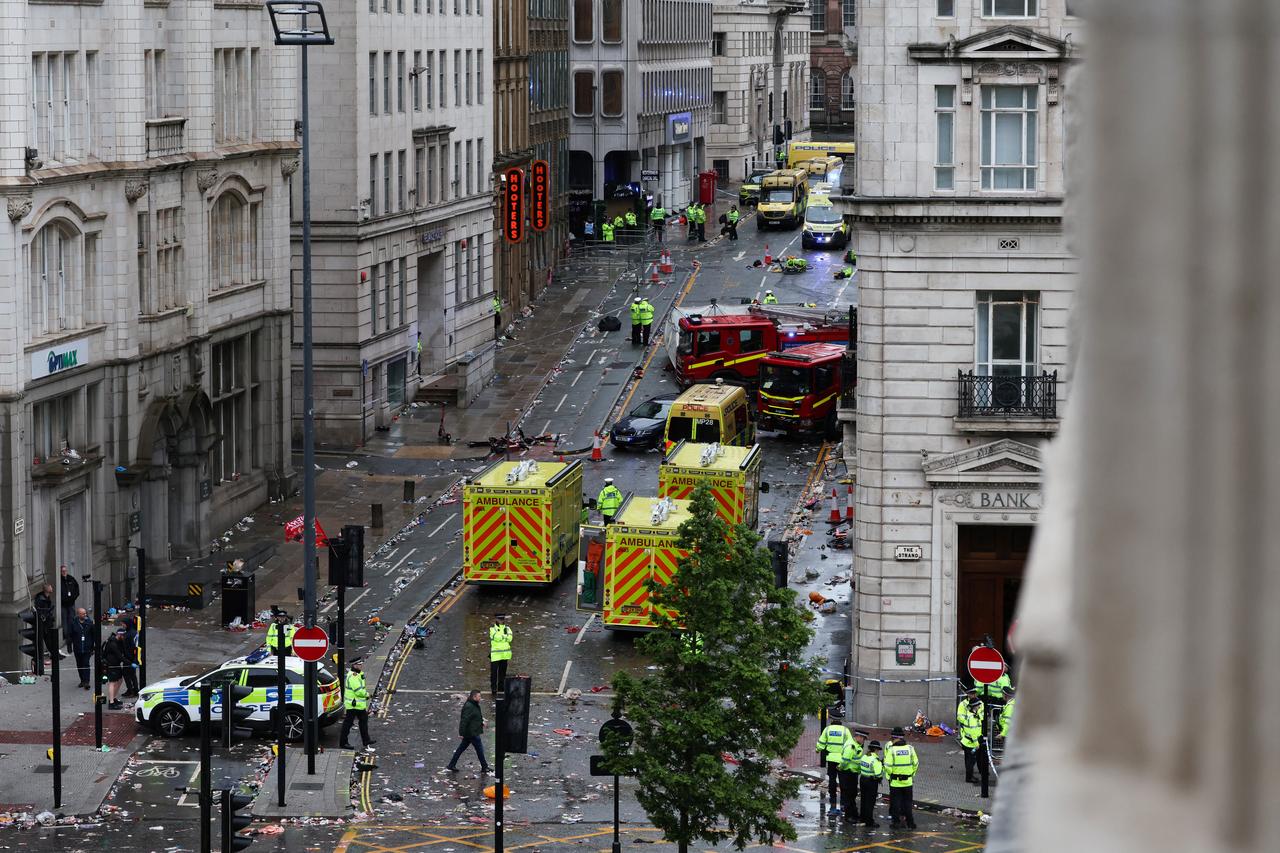 Police officers investigate the scene of an incident in Water Street, on the sidelines of an open-top bus victory parade for Liverpools Premier League title win, in Liverpool, north-west England on May 26, 2025. (Photo by Darren Staples / AFP)