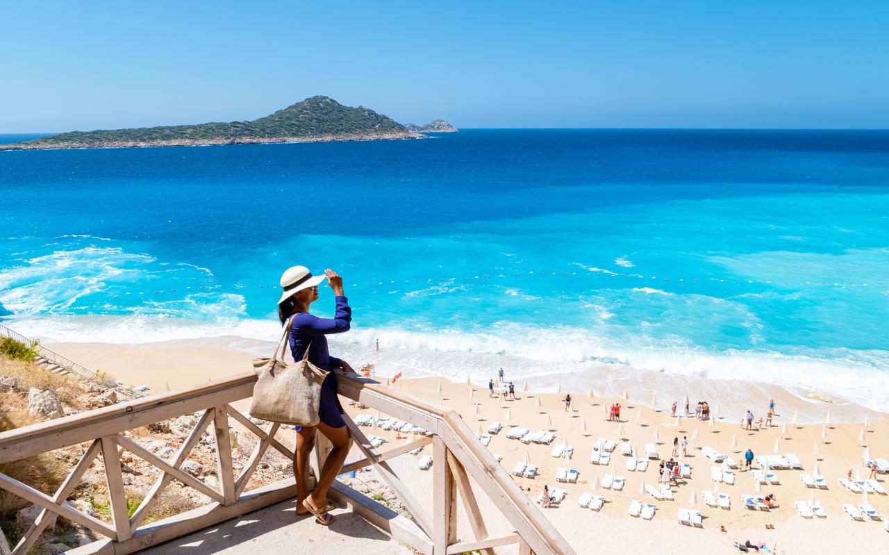A young Asian woman looking out over the Mediterranean Sea, Kas, Antalya, Türkiye. (Adobe Stock Photo)