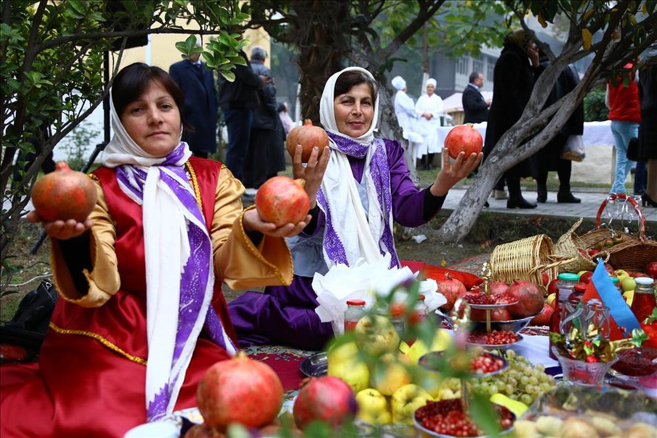 Women in traditional attire with pomegranates at the Goychay Pomegranate Festival in Azerbaijan. (AA Photo)