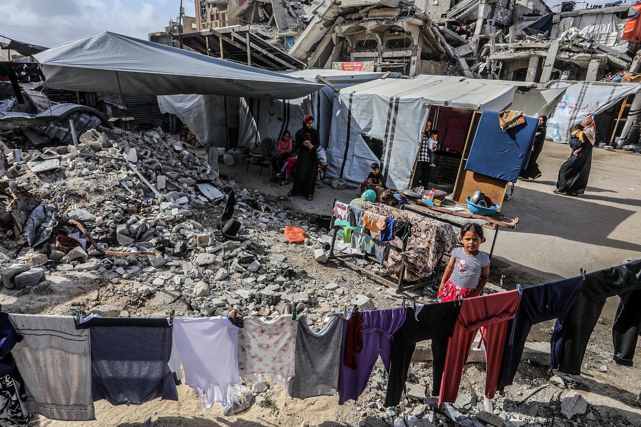 RAFAH, GAZA - MAY 27: A Palestinian family, forced to leave their home and now struggles to survive in the Al-Mawasi area of Rafah declared a  humanitarian zone  in Gaza, next to the rubble of destroyed homes and a garbage container on May 27, 2025. Being unable to find shelter, the family suffers from hunger and lack of access to clean water. The family was displaced due to evacuation leaflets dropped by the Israeli army on eastern Khan Yunis. ( Abed Rahim Khatib - Anadolu Agency )