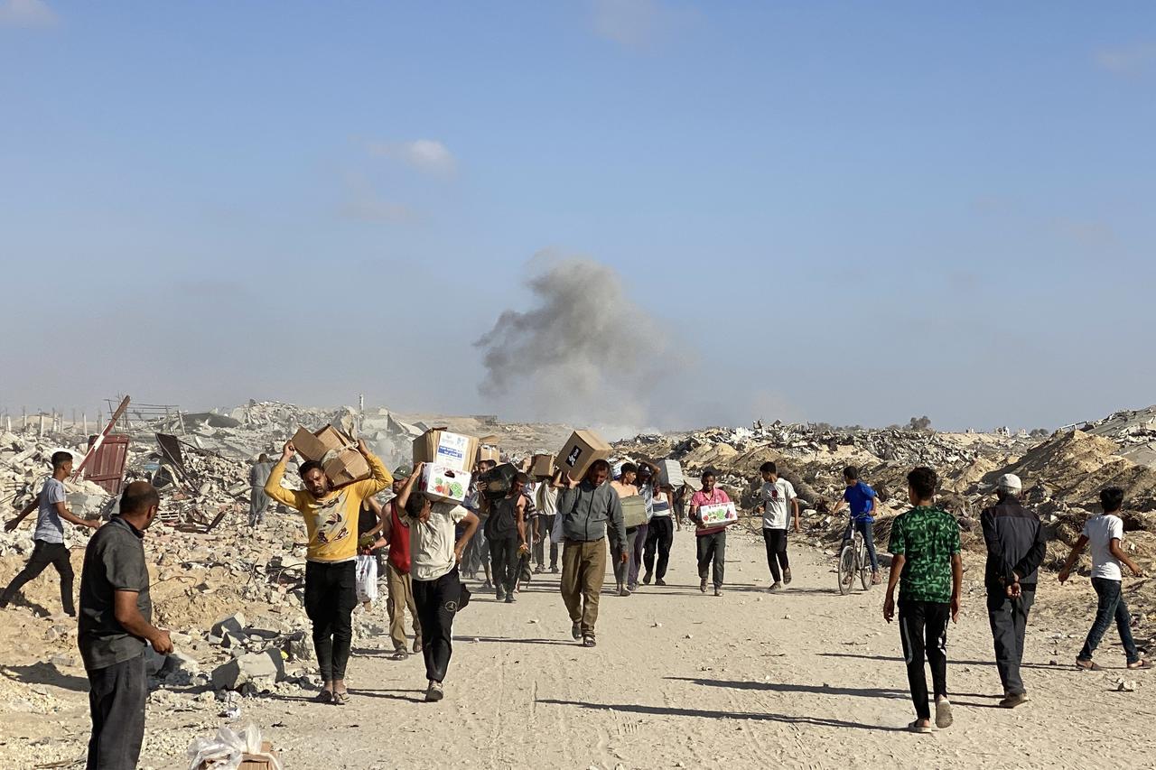 Displaced Palestinians receive food packages from a US-backed foundation pledging to distribute humanitarian aid in western Rafah in the southern Gaza Strip on May 27, 2025. Thousands of Palestinians rushed into a new aid distribution centre run by a US-backed group in southern Gaza on May 27, AFP journalists reported, leading to chaotic scenes as Israel implemented a new distribution system. The incident in Rafah came days after the partial easing of a total aid blockade on the territory that Israel imposed on March 2, leading to severe shortages of food and medicine. (Photo by AFP)